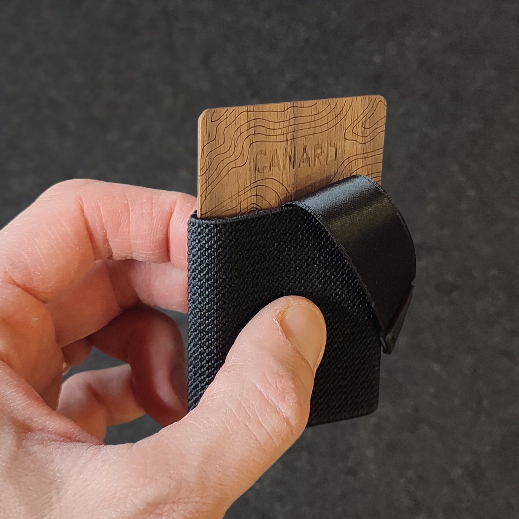 Hand hält Canard Essentials Ultralight Explore Wood Wallet – minimalistische Holzkarten herausziehbar aus Slim Wallet